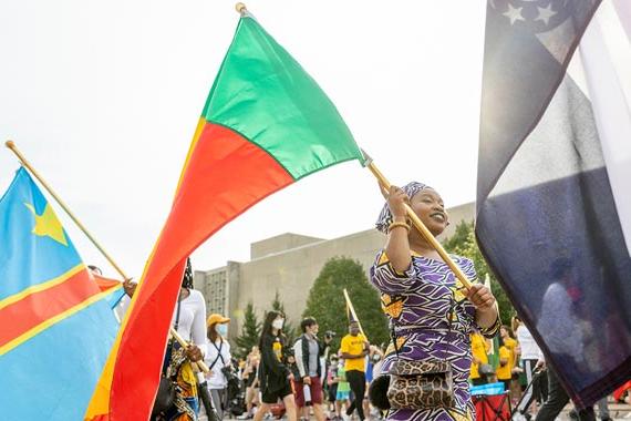 International students carrying their nation's flag during a ceremony